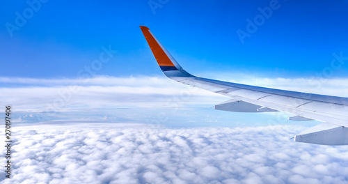 Bussiness and travel concept. Aerial view through window inside aircraft cabin with beautiful blue sky and cloud with sunlight, copy space, top view