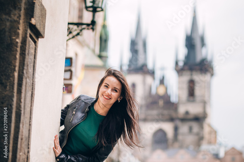 Street portrait of adorable brunette woman with long hair posing at Old Town Square in Prague. smiling pretty brunette girl, lifestyle. observatory of astronomical clock tower in Prague, Czech © Stanislav