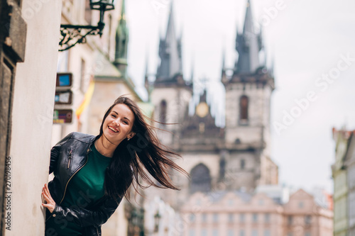 Street portrait of adorable brunette woman with long hair posing at Old Town Square in Prague. smiling pretty brunette girl, lifestyle. observatory of astronomical clock tower in Prague, Czech