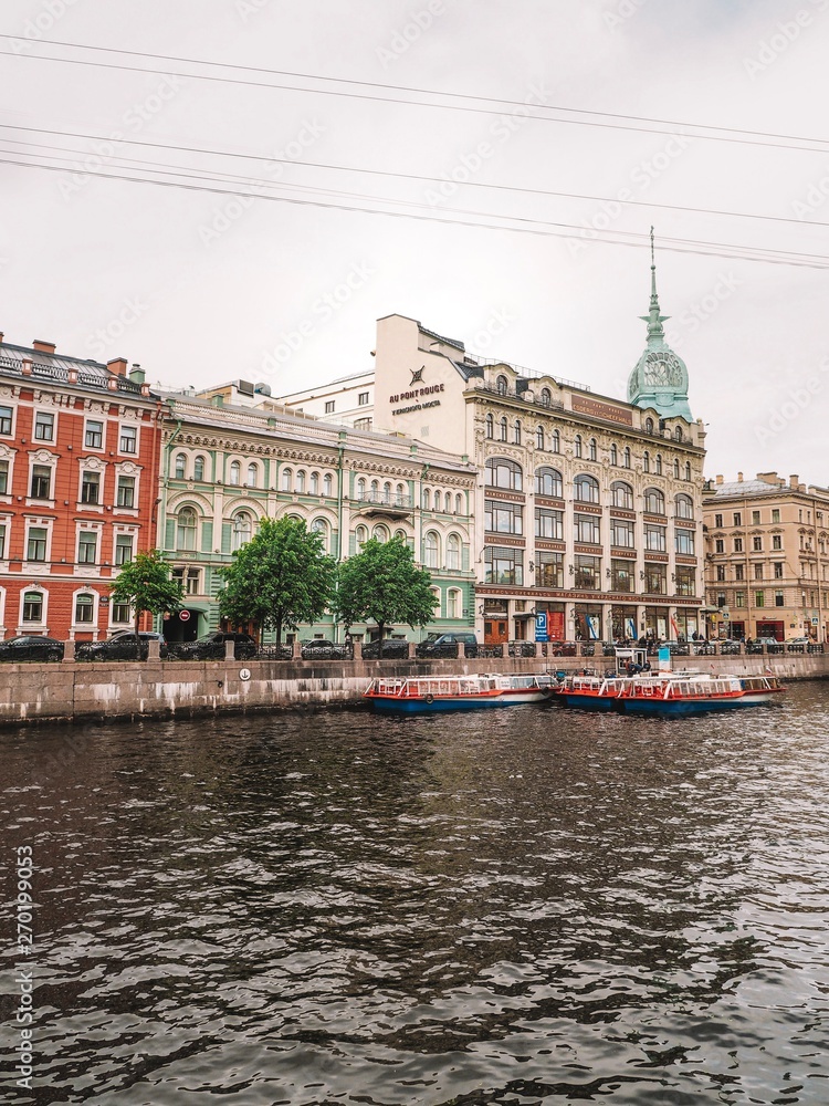 Embankment in Saint Petersburg pass a tour boat with tours all over the facades of historic buildings