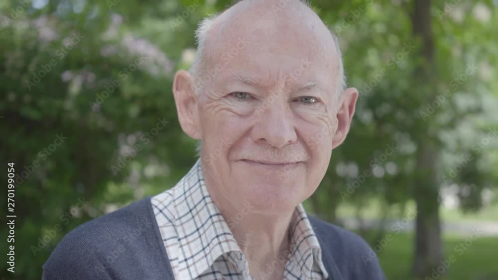 Portrait of cute smilling old man sitting on a bench in the park. Adorable mature grandfather resting on a sunny warm spring day outdoors. Portrait of cute smilling old man sitting on a bench in the park. Adorable mature grandfather resting on a sunny warm spring day outdoors.