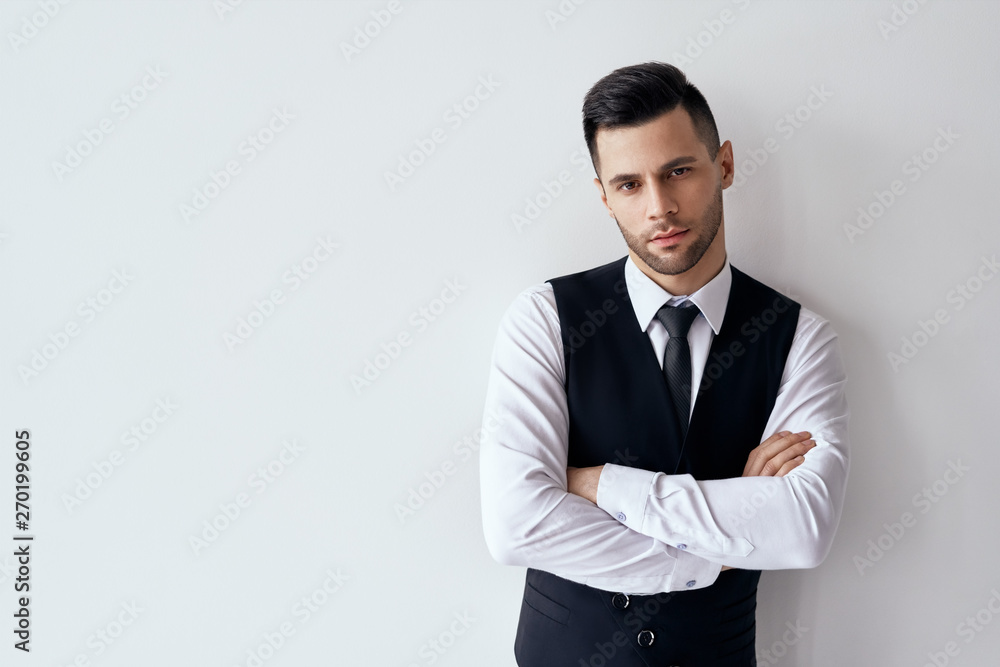Handsome confident man in elegant suit with crossed arms on white background Handsome confident man in elegant suit with crossed arms on white background