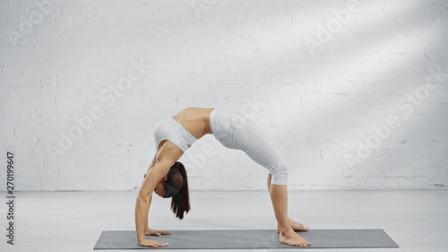 side view of woman practicing urdhva dhanurasana and eka pada urdhva dhanurasana photo