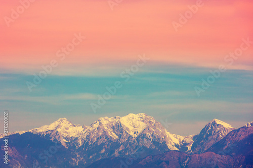 Mountain landscape in the evening. Mountain range covered with snow against the gradient sunset sky