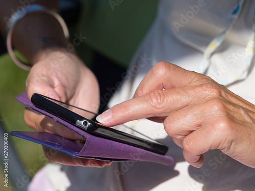 Close up of a lady's finger tapping a smart phone screen photo