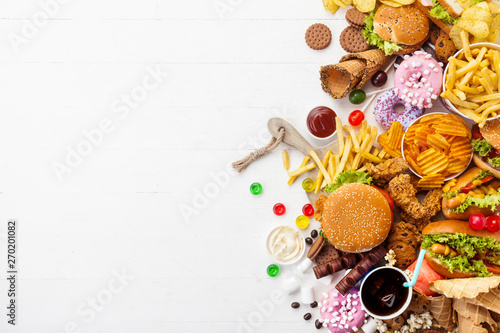 Fast food dish on white background. Take away unhealthy set including burgers, sauces, french fries, donuts, cola, sweets, icecream and biscuit. Diet temptation resulting in improper nutrition.