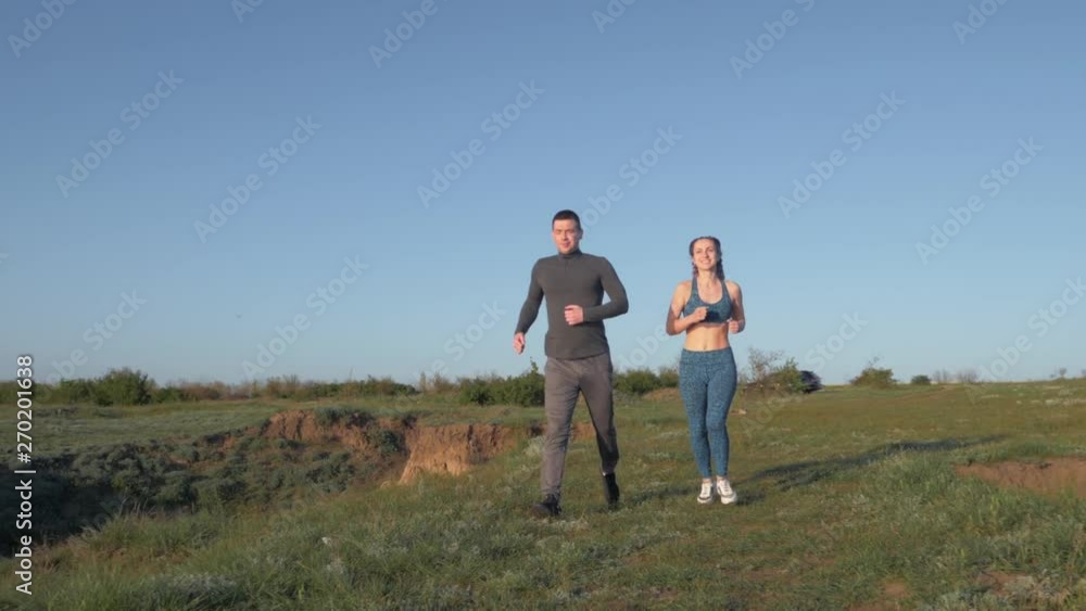jog outdoors, happy athletic guy with girl enjoying jog in nature in sunny daylight after outdoor cardio workout against blue sky jog outdoors, happy athletic guy with girl enjoying jog in nature in sunny daylight after outdoor cardio workout against blue sky