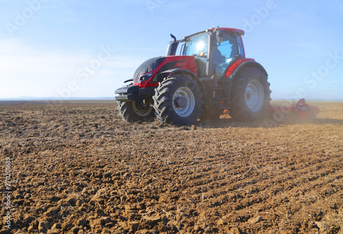 Obraz na plátne Farmer on tractor prepares land in spring