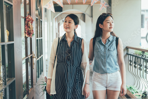 Wallpaper Mural group of young asian girl friends walking in second floor of mall shopping relax smiling looking around with curious face. beautiful women laughing staring inside window with england flag hanging Torontodigital.ca