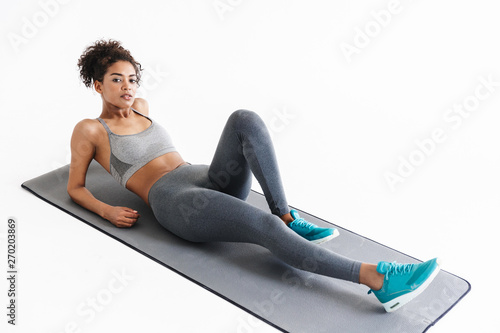 Amazing stronger sports fitness african woman make exercises isolated over white wall background.