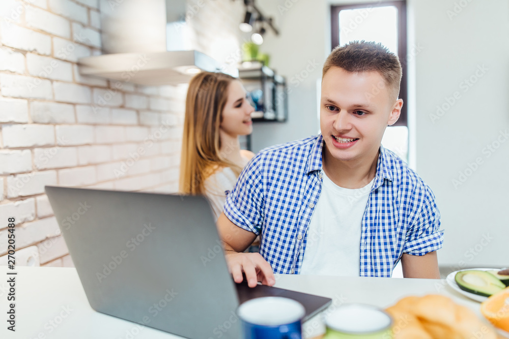 Couple in love enjoy sharing coffee break together in modern kitchen space, while searching for new recipes on computer notebook. Couple in love enjoy sharing coffee break together in modern kitchen space, while searching for new recipes on computer notebook.