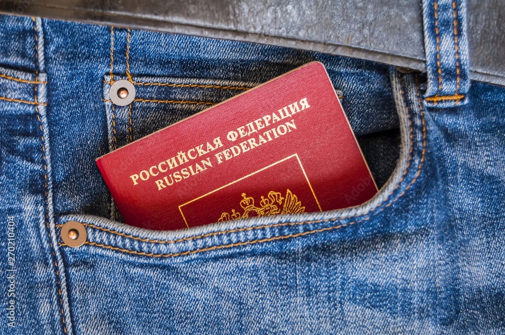 A red passport of Russia sticking from a pocket of blue denim jeans. Russian  passport, Russian tourist travel concept image. Stock Photo | Adobe Stock