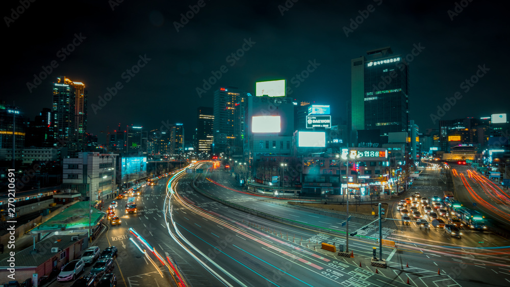 Obraz premium Seoul, South Korea - March 2018: long exposure of an urban landscape that incorporates moving cars and illuminated buildings, from a raised point during the night.