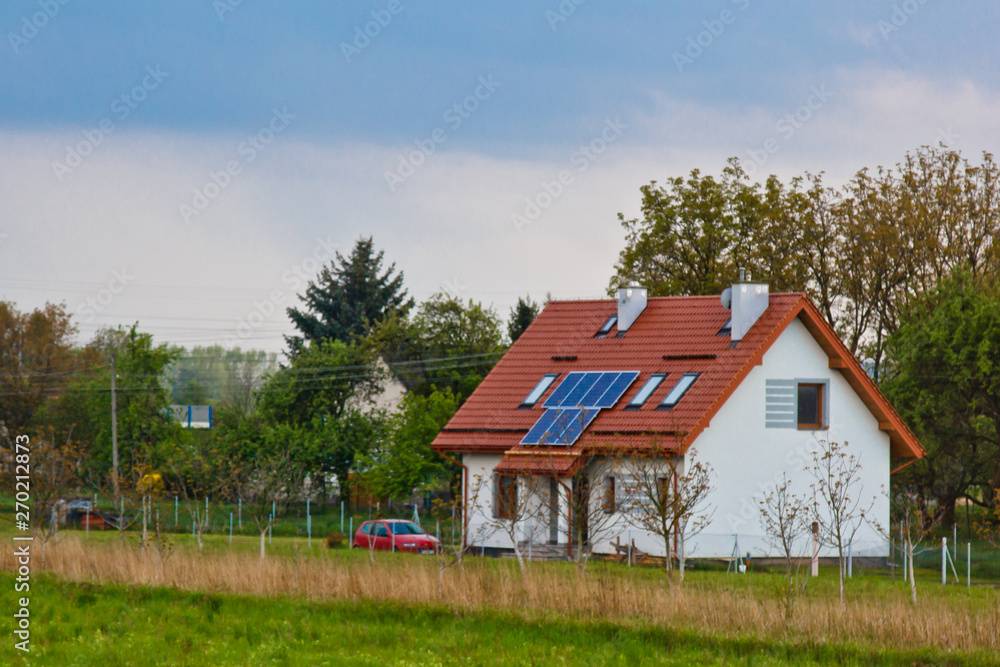 solar battery on the roof of a rural house under a blue sunny sky. solar energy, alternative electricity