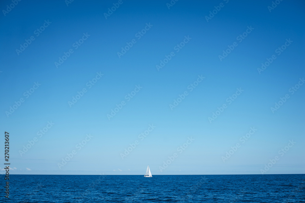 Fototapeta premium Alone boat at an open sea in the sunny weather day, Greece. Free space for text or logo