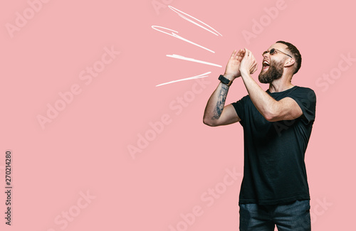 Картината върху платно Young man keeping hand near mouth and screaming and poin for your text