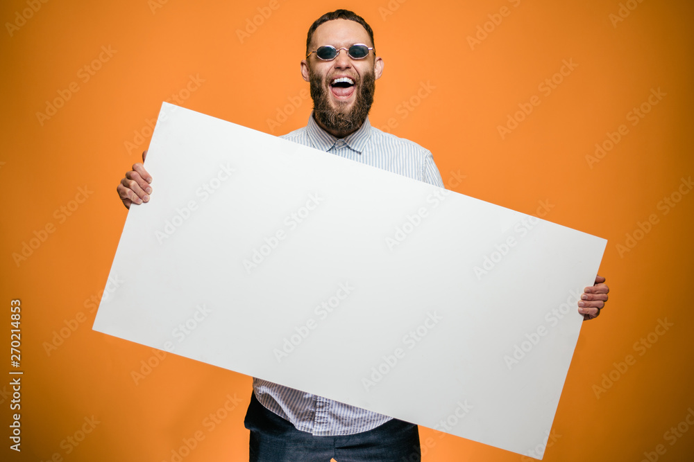 Hipster man holding a poster with blank space for your text. - obrazy, fototapety, plakaty 