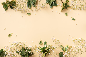 Small white gypsophila flowers on pastel yellow background. Women's Day, Mother's Day, Valentine's Day, Wedding concept. Flat lay. Top view. Copy space
