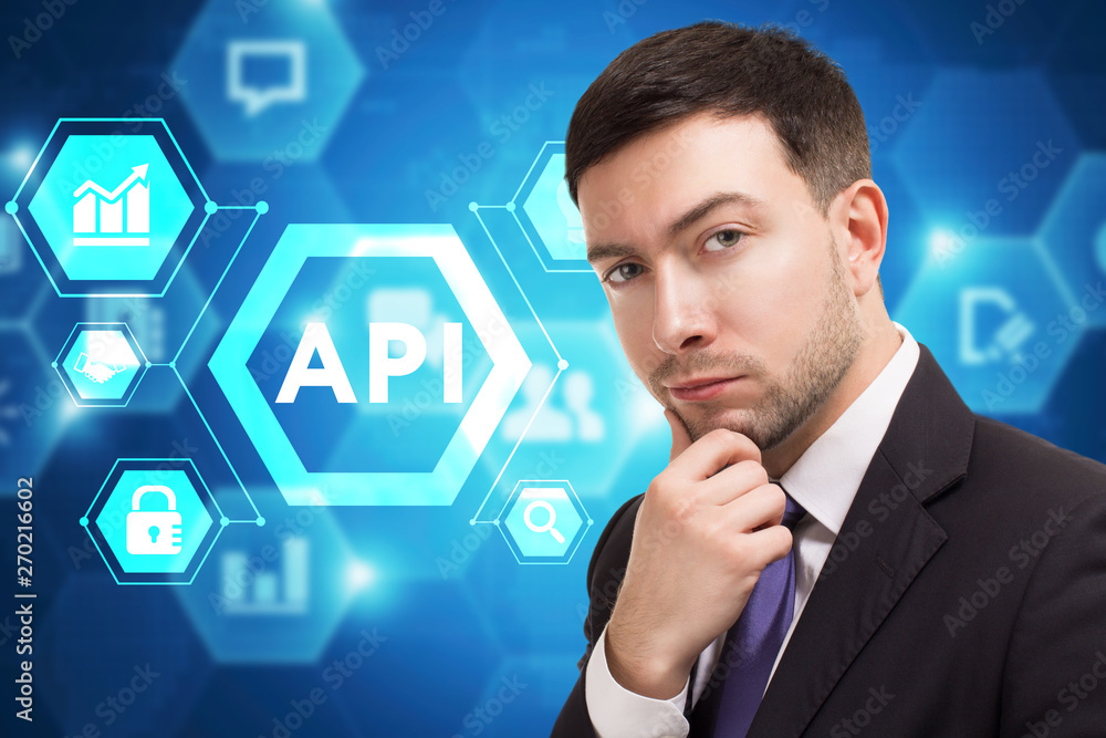 The concept of business, technology, the Internet and the network. A young entrepreneur working on a virtual screen of the future and sees the inscription: API The concept of business, technology, the Internet and the network. A young entrepreneur working on a virtual screen of the future and sees the inscription: API
