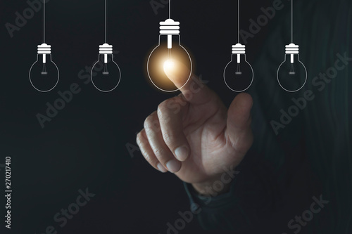 Innovation or creative concept of finger touching a light bulb and copy space for insert text.