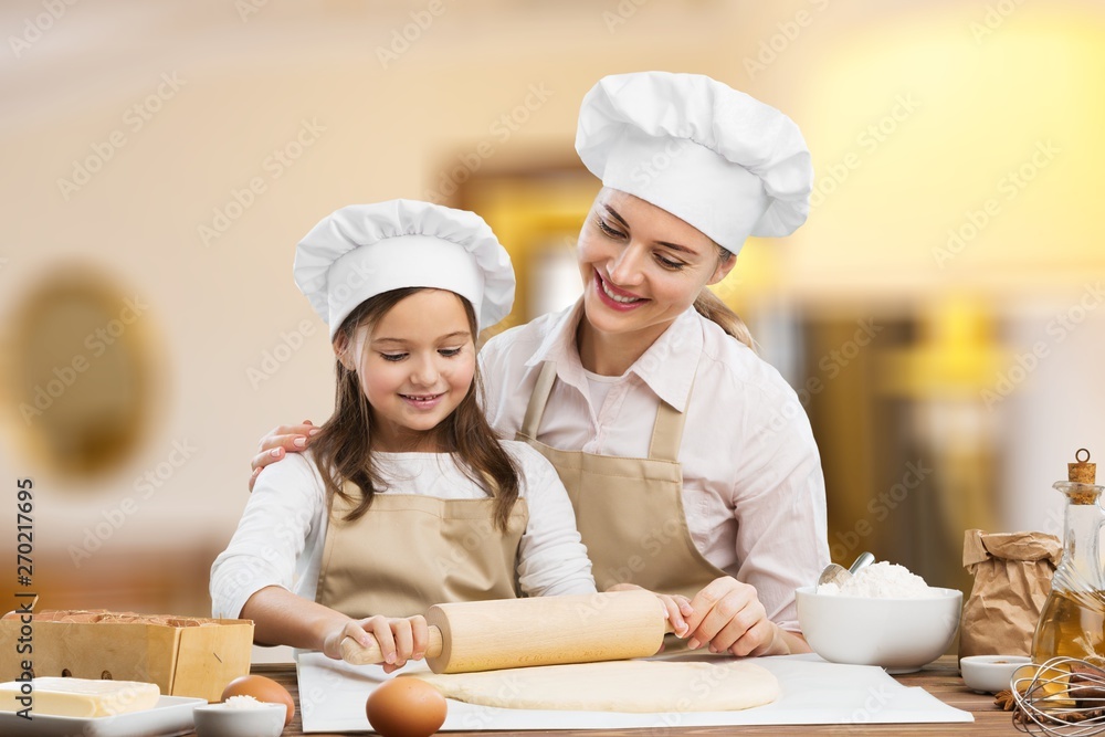 Portrait of adorable little girl and her mother baking together Portrait of adorable little girl and her mother baking together