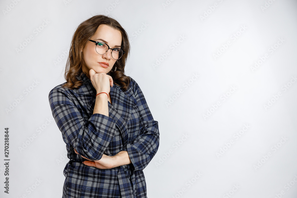 Young beautiful girl in a strict plaid suit posing on a white background. Emotions and feelings at work and office. Young beautiful girl in a strict plaid suit posing on a white background. Emotions and feelings at work and office.