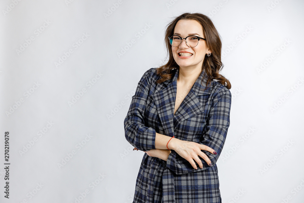 Young beautiful girl in a strict plaid suit posing on a white background. Emotions and feelings at work and office. Young beautiful girl in a strict plaid suit posing on a white background. Emotions and feelings at work and office.