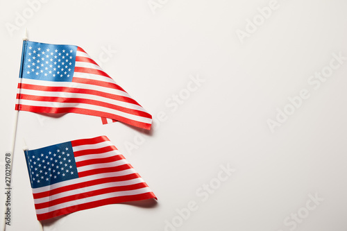 top view of bright american flags on white background with copy space