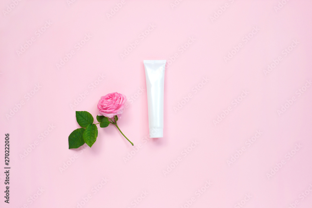Natural organic cosmetic packaging mock up with flower on pastel pink background. Mock-up bottle for branding and label