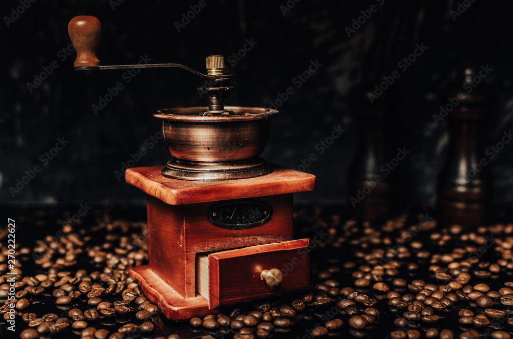 Old wooden coffee grinder and coffee beans on concrete background. Old wooden coffee grinder and coffee beans on concrete background.