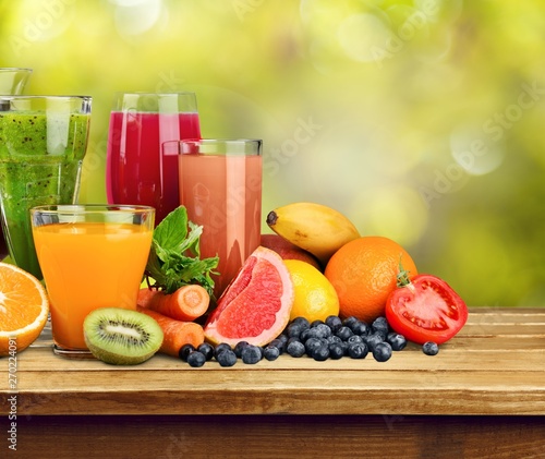 Fototapeta Naklejka Na Ścianę i Meble -  Fresh ripe healthy fruits and juices in glasses