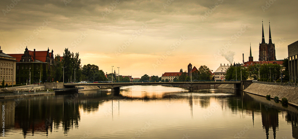 Obraz premium View of St. John the Baptist cathedral and other historic buildings in old town Wroclaw from Oder (Odra) river