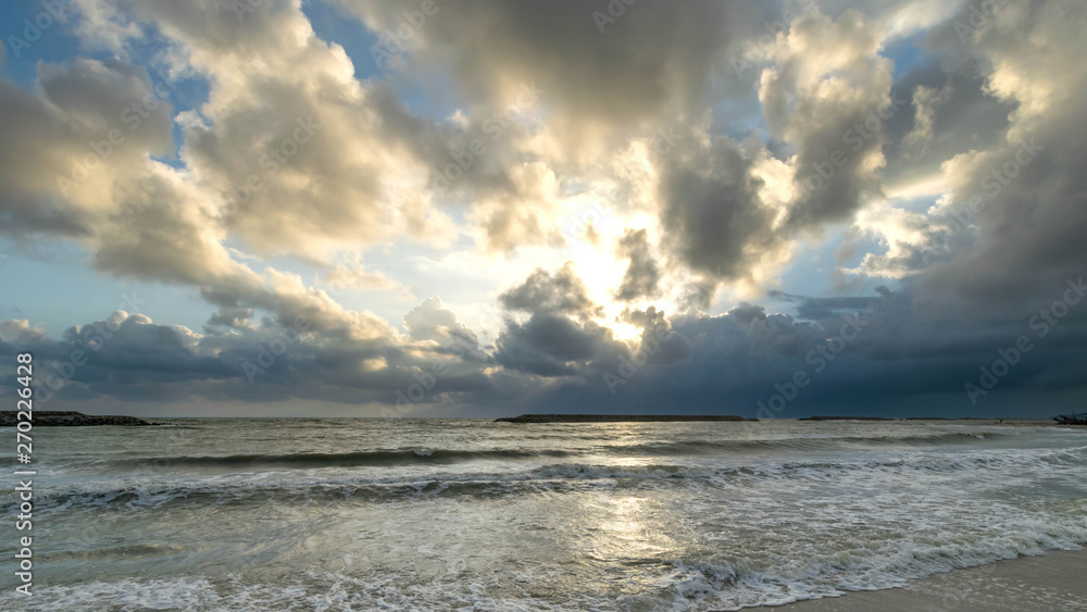 Sand, sea and clouds at sunrise
