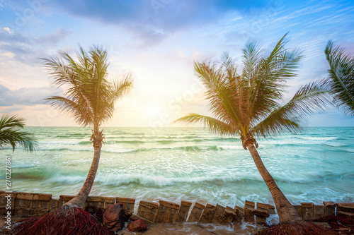 Beautiful early morning sunrise over Coconut tree with the sea the horizon at Hat chao lao beach in Chanthaburi Thailand.