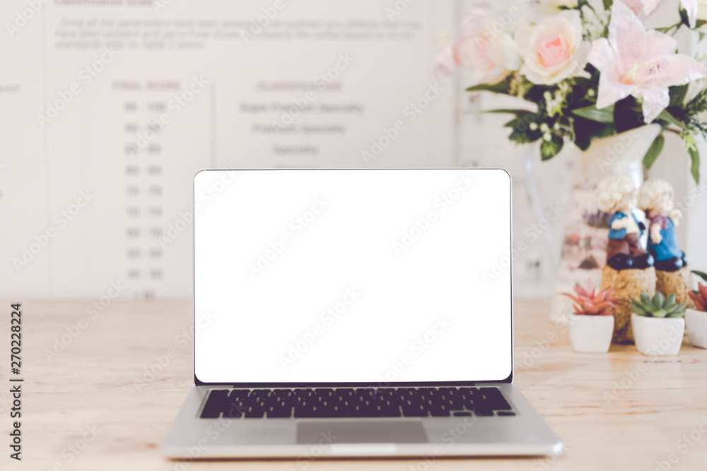 Mockup image of laptop with blank white screen on wooden table of In the coffee shop. Mockup image of laptop with blank white screen on wooden table of In the coffee shop.
