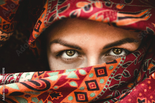 beautiful eyes. The face of a woman in an red Indian scarf. Expressive look. Oriental beauty photo