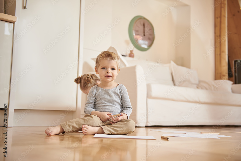 Adorable little boy with pencil sitting on the floor Adorable little boy with pencil sitting on the floor