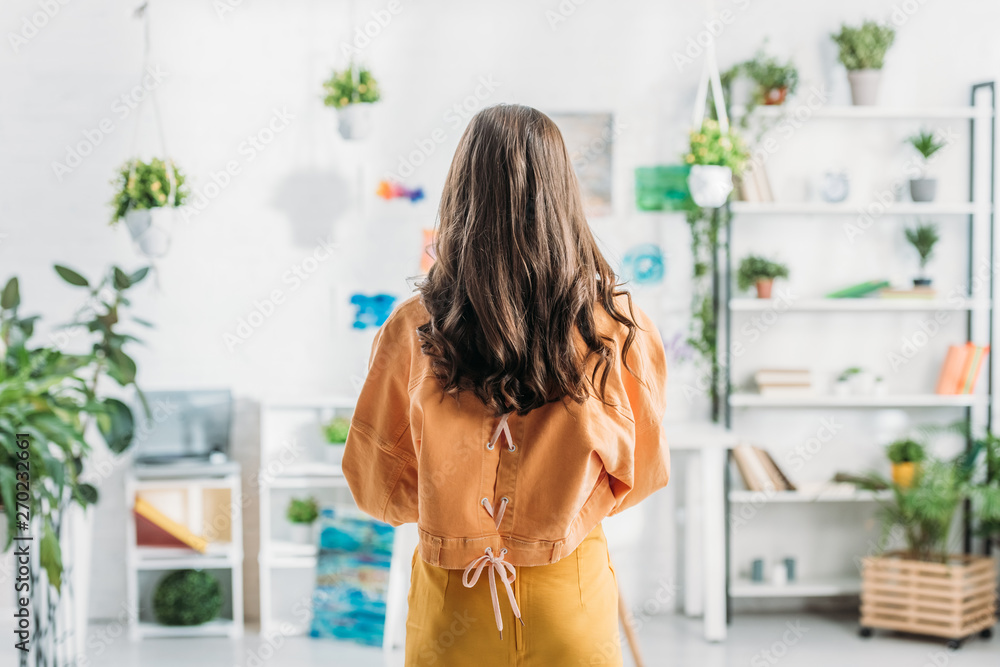 back view of young woman standing in spacious room at home back view of young woman standing in spacious room at home