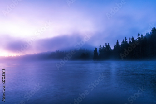 Stunning image of the foggy lake. Dramatic morning sunrise scene. 