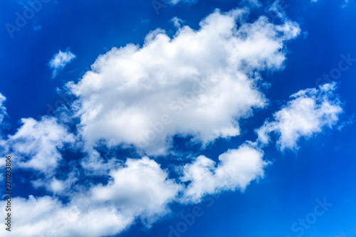 Bright blue sky with clouds and sunlight. Background.