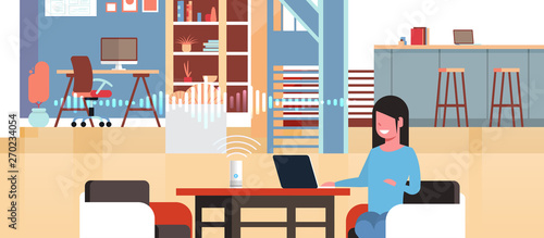 woman sitting at workplace with laptop using intelligent smart speaker with voice recognition artificial intelligence assistance concept modern workspace office interior flat horizontal portrait