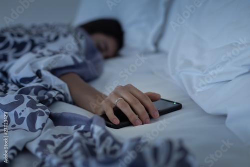 Fotografia Young woman falls asleep while using her phone