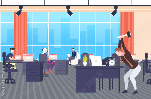 angry businessman hitting alarm clock by hummer tired business man trying to destroy classic watch on workplace desktop deadline concept modern co-working office interior full length horizontal
