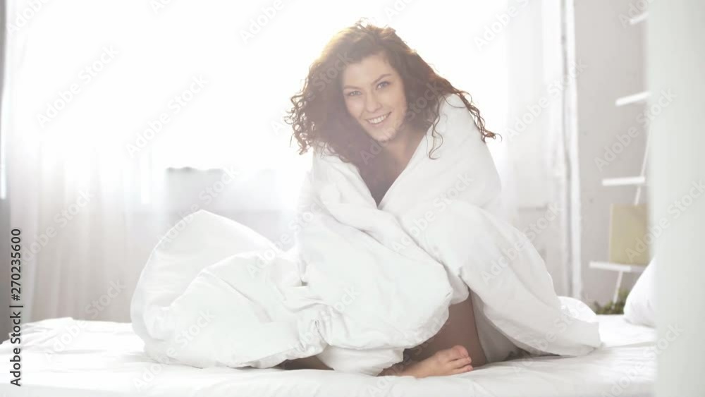 beautiful girl covered in blanket smiling and looking at camera at home beautiful girl covered in blanket smiling and looking at camera at home