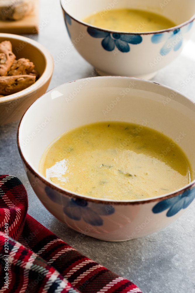 Homemade Zucchini and Carrot Soup with Crispy Bread at Lunch Table. Homemade Zucchini and Carrot Soup with Crispy Bread at Lunch Table.