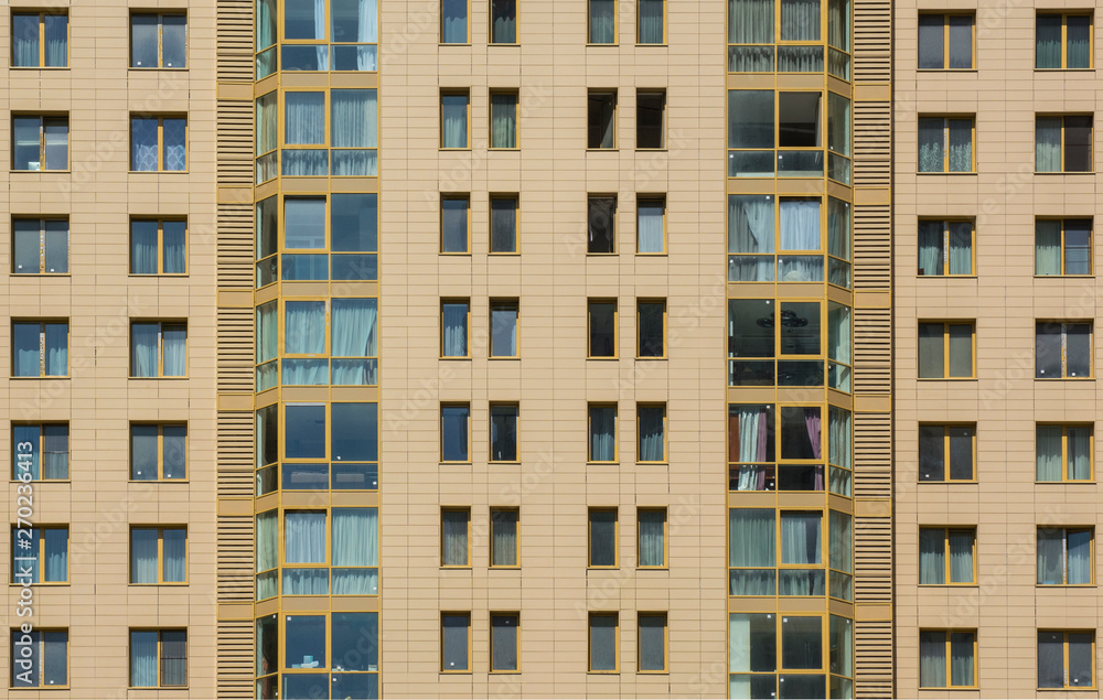 Facade of a multi-storey apartment building against the blue sky