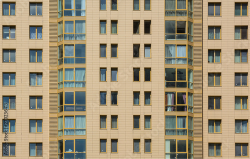 Facade of a multi-storey apartment building against the blue sky © Alex