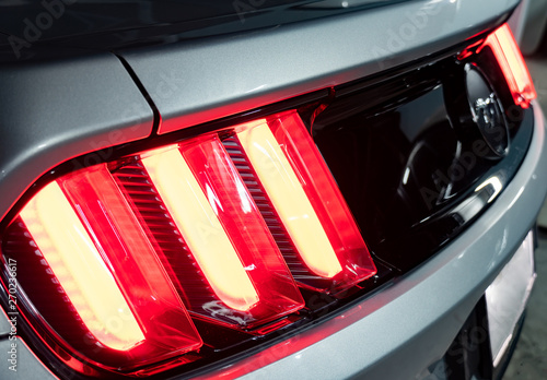 Fotografie Bangkok -Thailand  May 28, 2019: The tail light of a silver 2015 50th Anniversary Ford Mustang with water drops on the car