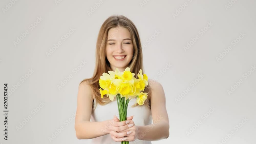 Cute girl holds a bouquet of flowers and smiles slow motion Cute girl holds a bouquet of flowers and smiles slow motion