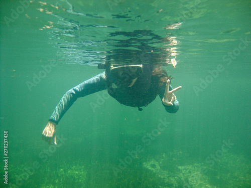 Girl snorkeling at Sucuri river water surface, crystal clear, transparent blue river, in Bonito, Mato Grosso do Sul, Brazil photo